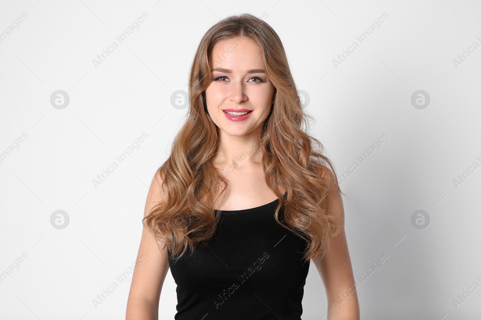 Photo of Portrait of young woman with long beautiful hair on light background