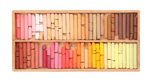 Photo of Set of soft pastels on white background in wooden box, top view. Drawing material