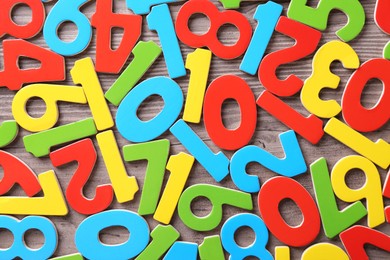 Photo of Colorful numbers on wooden school desk, top view