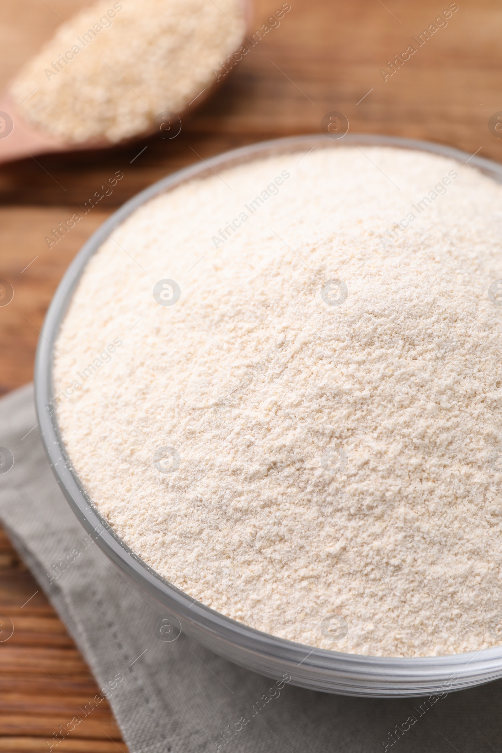 Photo of Glass bowl with quinoa flour on table, closeup