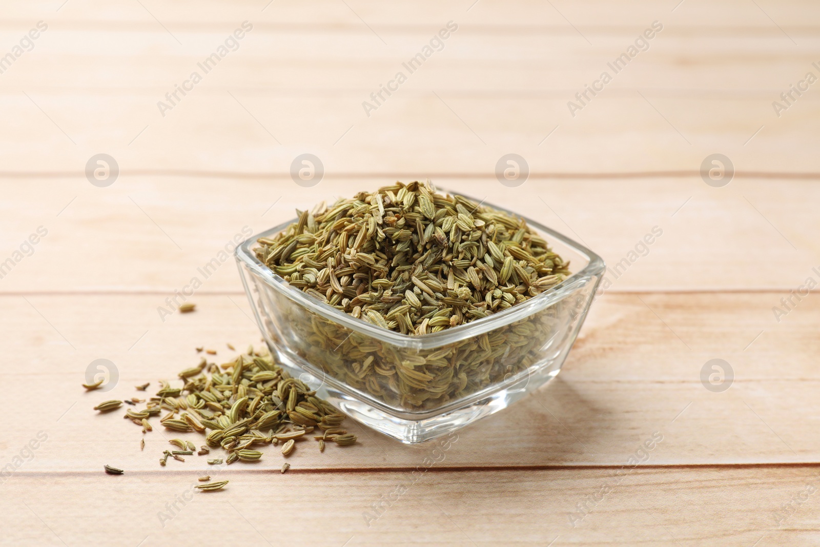 Photo of Bowl with fennel seeds on wooden table