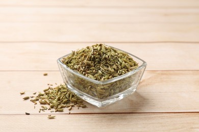 Bowl with fennel seeds on wooden table