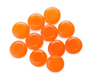 Many orange cough drops on white background, top view