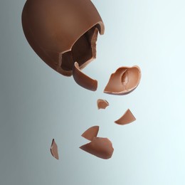 Image of Exploded milk chocolate egg on color background
