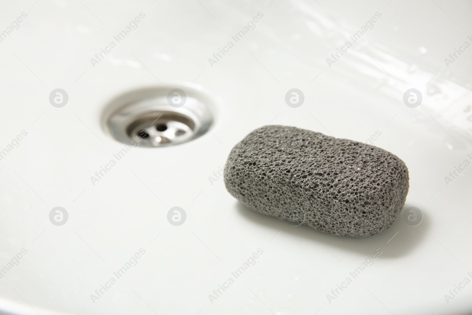 Photo of Pumice stone in sink, closeup. Space for text