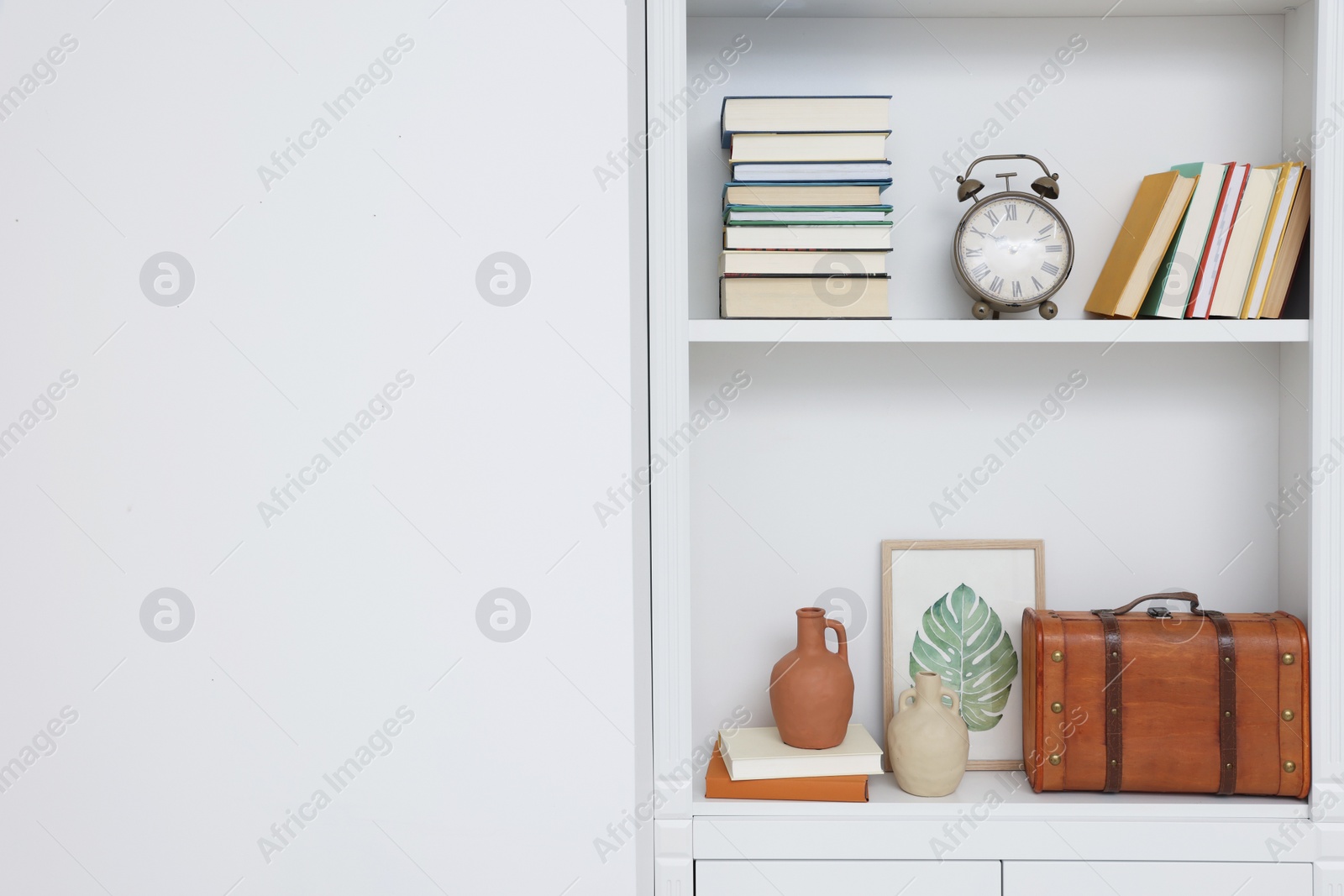 Photo of Books and different decorative elements on shelving unit indoors, space for text