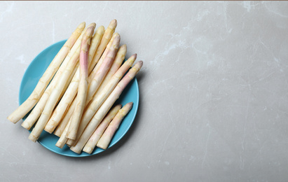 Fresh white asparagus on grey marble table, top view. Space for text