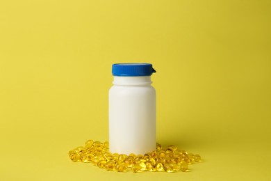 Medicine bottle and pills on yellow background