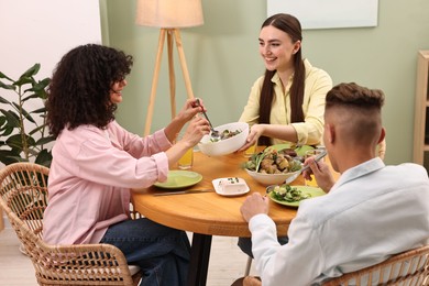 Friends having vegetarian meal at table in cafe