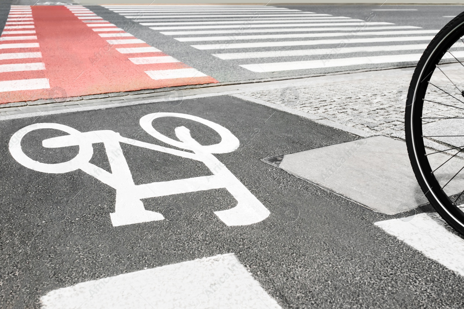 Photo of Bike lane with painted white bicycle sign and pedestrian crossing outdoors