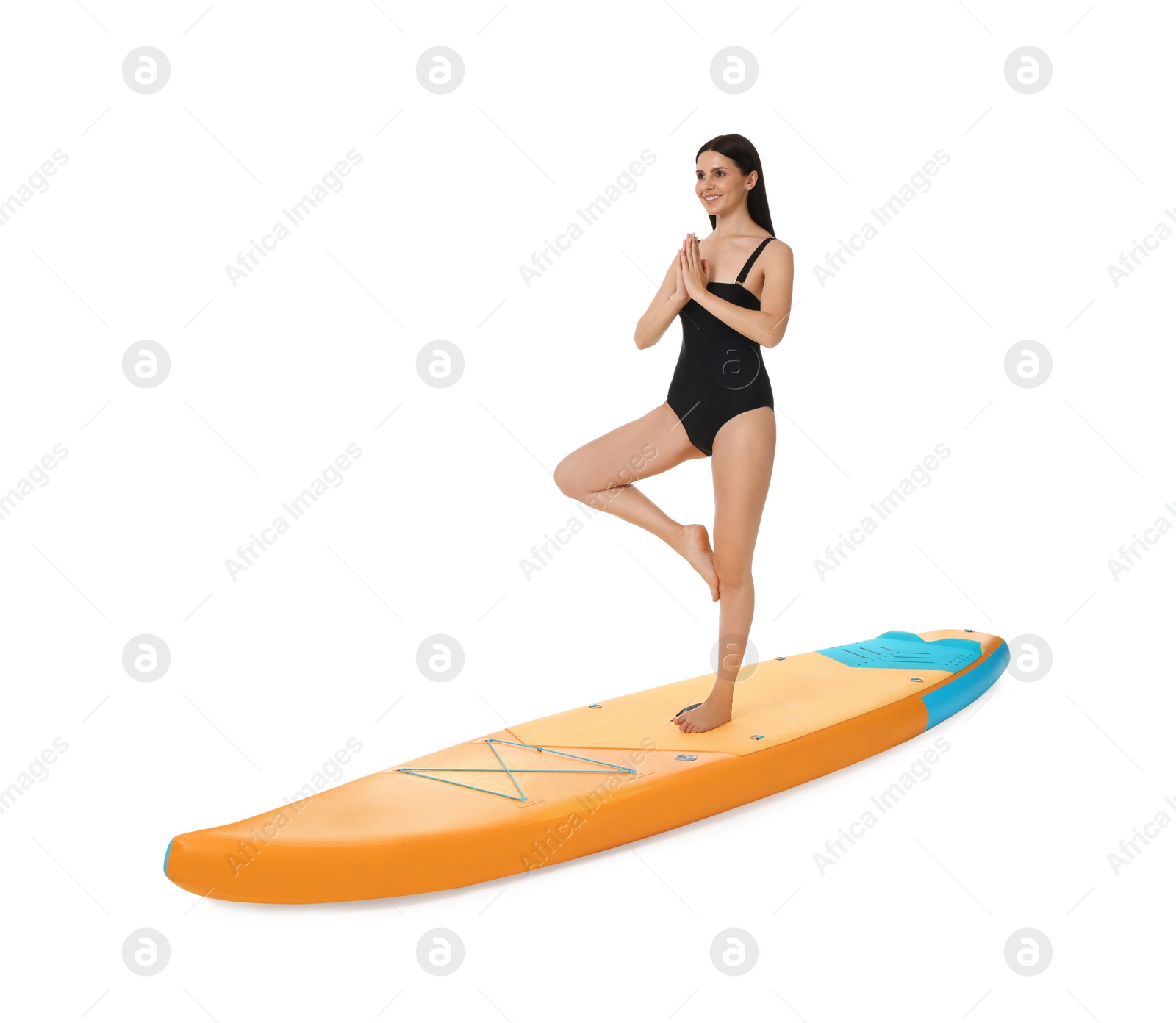 Photo of Happy woman practicing yoga on orange SUP board against white background