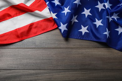 Photo of American flag on wooden table, top view. Space for text