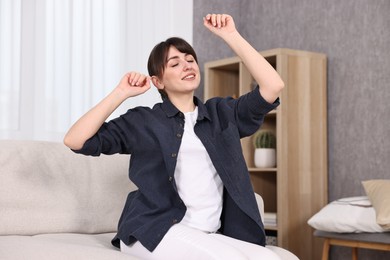 Photo of Beautiful young housewife on sofa at home