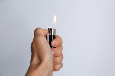 Woman holding black lighter on white background, closeup