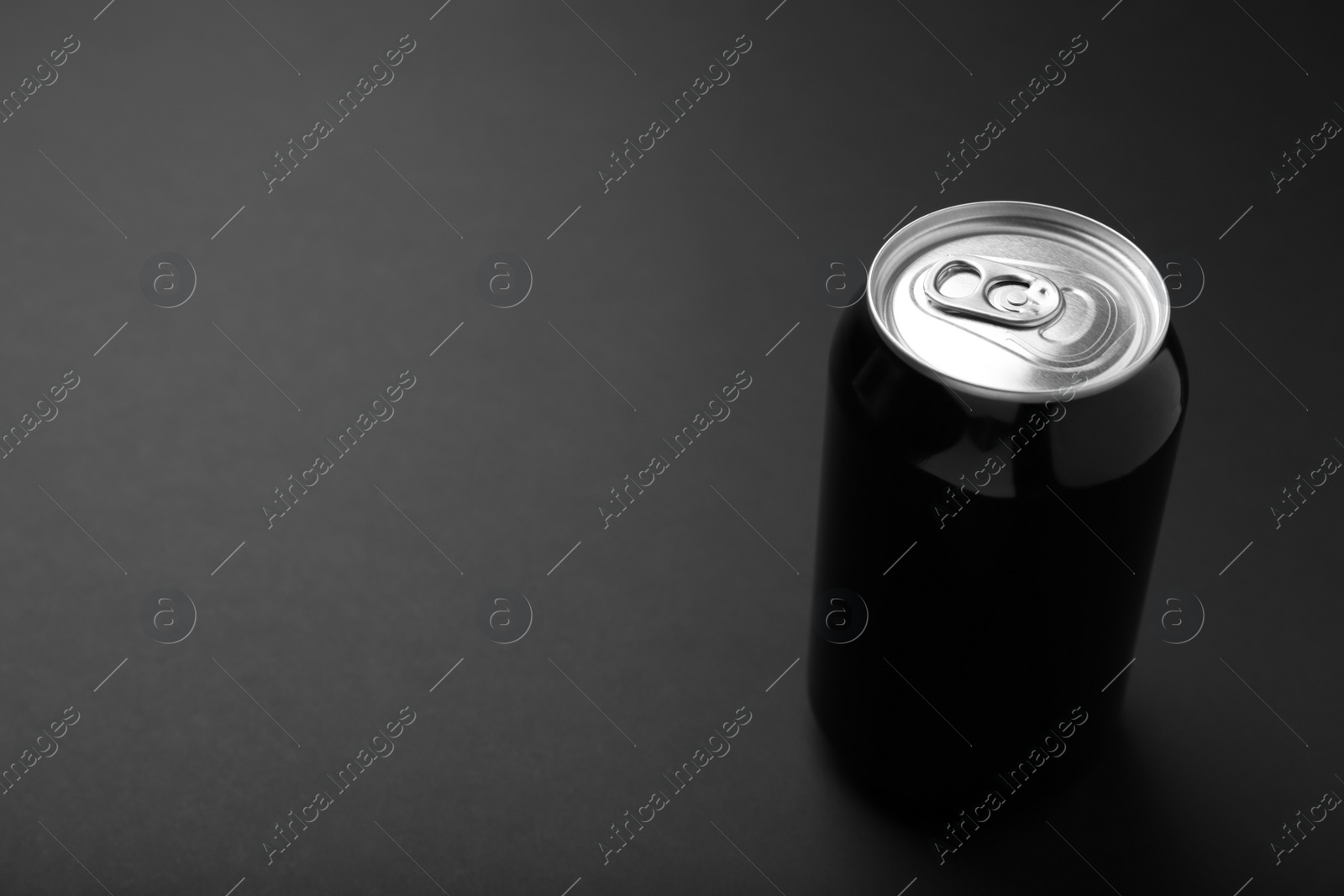 Photo of Can of energy drink on black background. Space for text