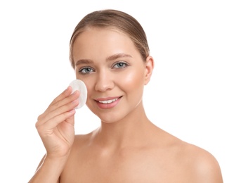 Beautiful young woman with cotton pad on white background