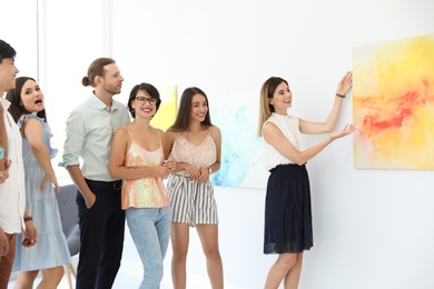 Group of people with guide at exhibition in art gallery