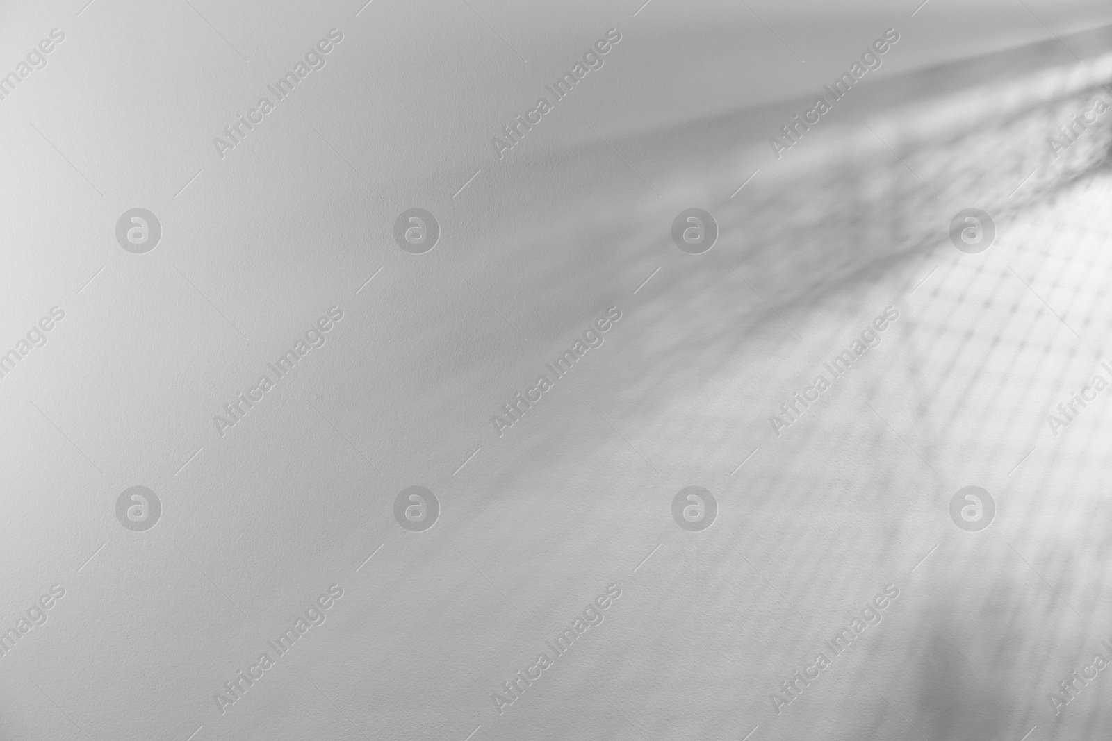 Photo of Light and shadows on white wall, space for text