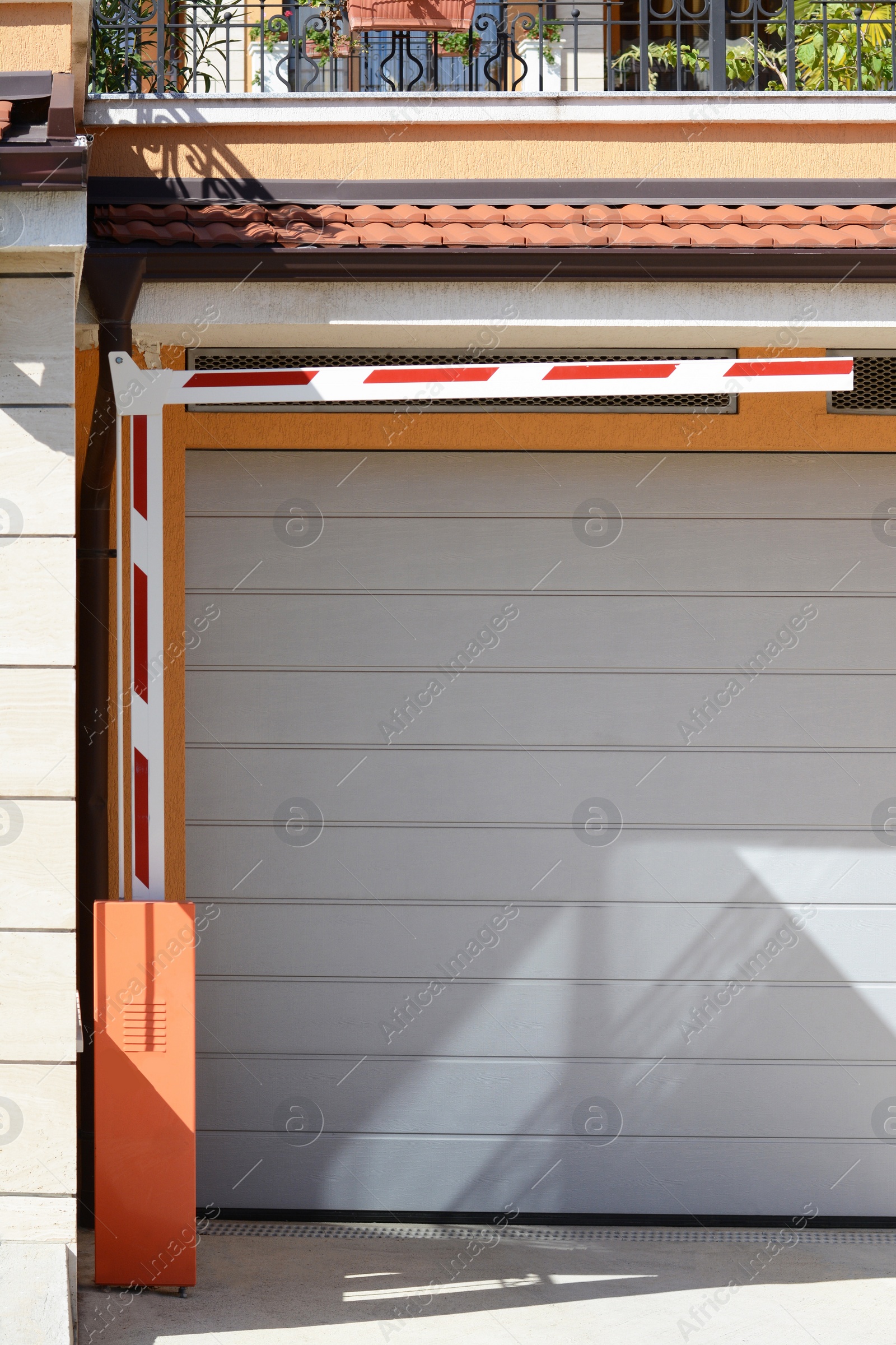 Photo of Modern automatic striped barrier near garage outdoors
