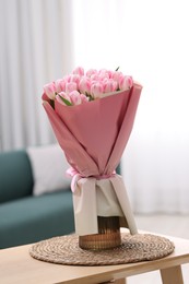 Photo of Beautiful bouquet of fresh pink tulips on table at home