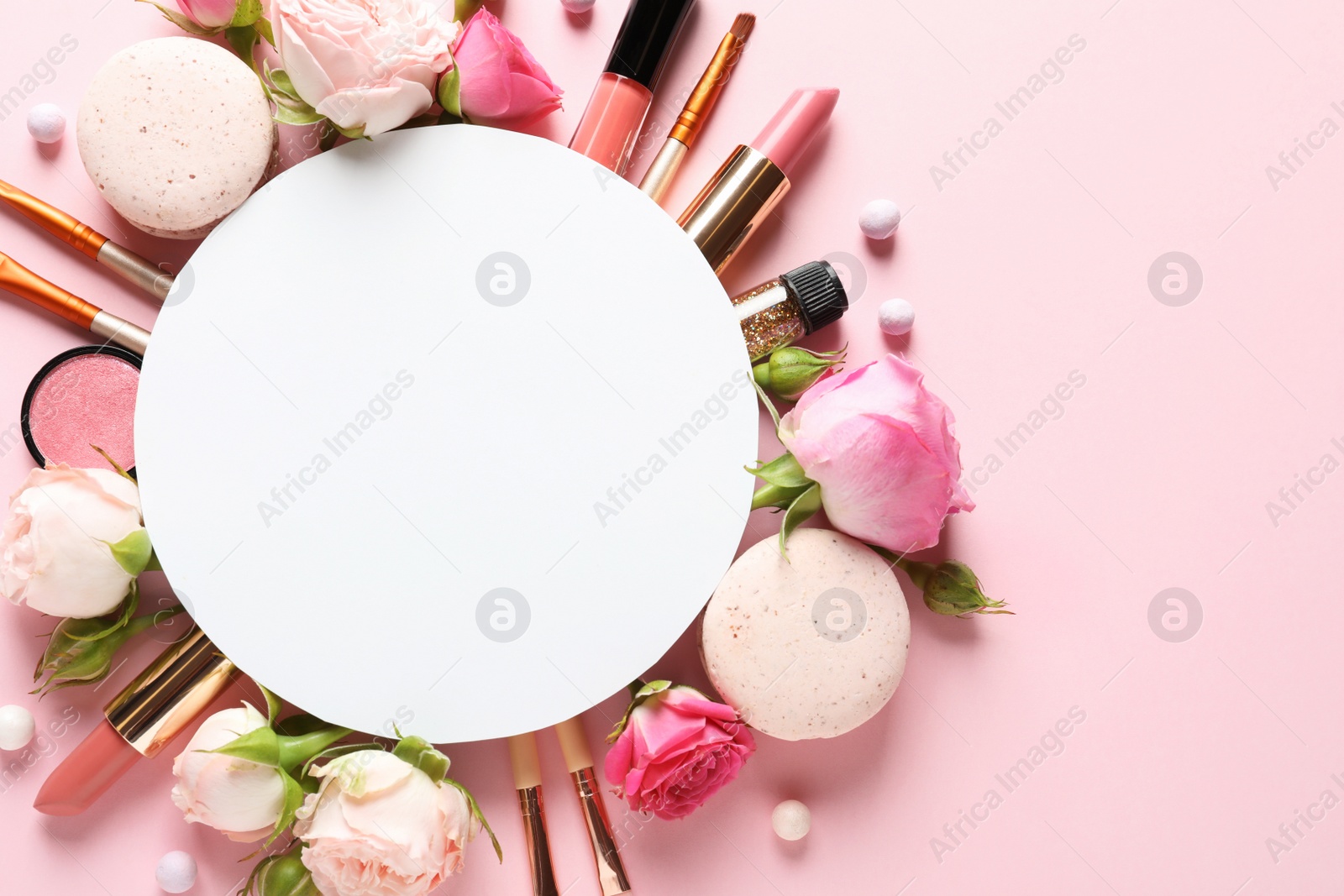 Photo of Flat lay composition with card and products for decorative makeup on pastel pink background