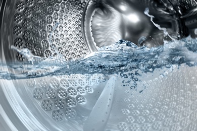 Image of Washing machine drum with water, closeup view