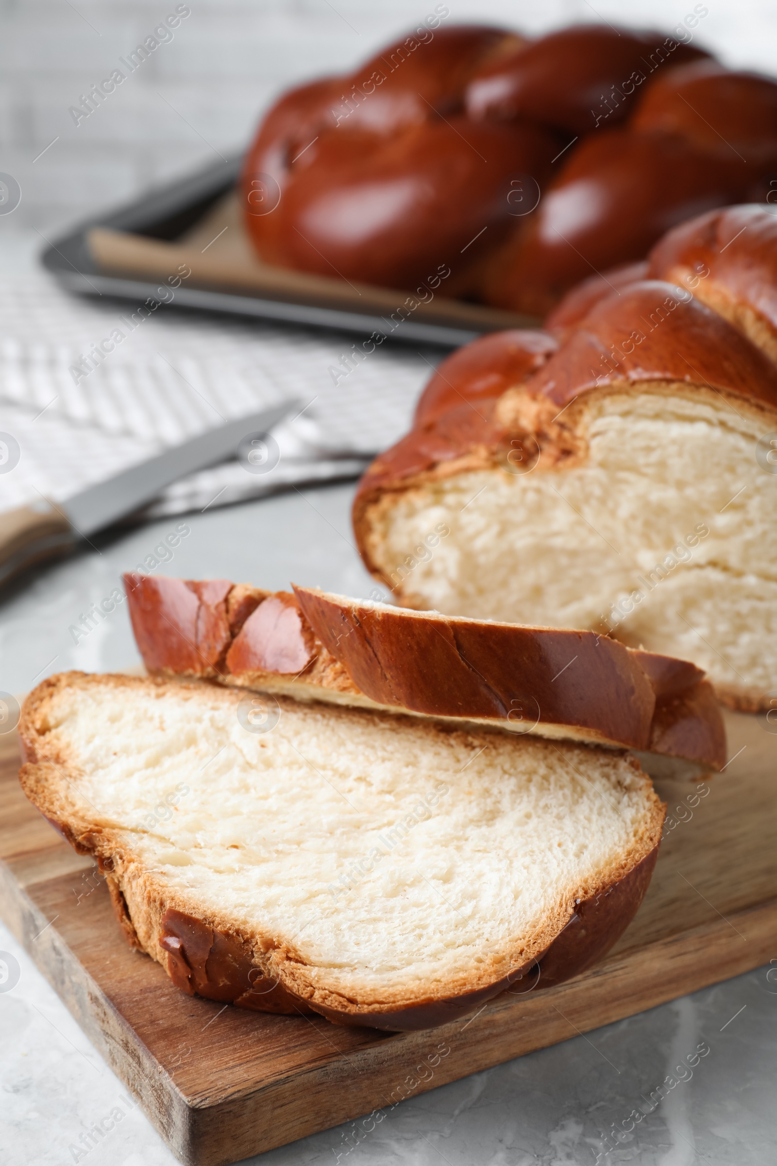 Photo of Cut homemade braided bread on grey table, closeup. Traditional Shabbat challah