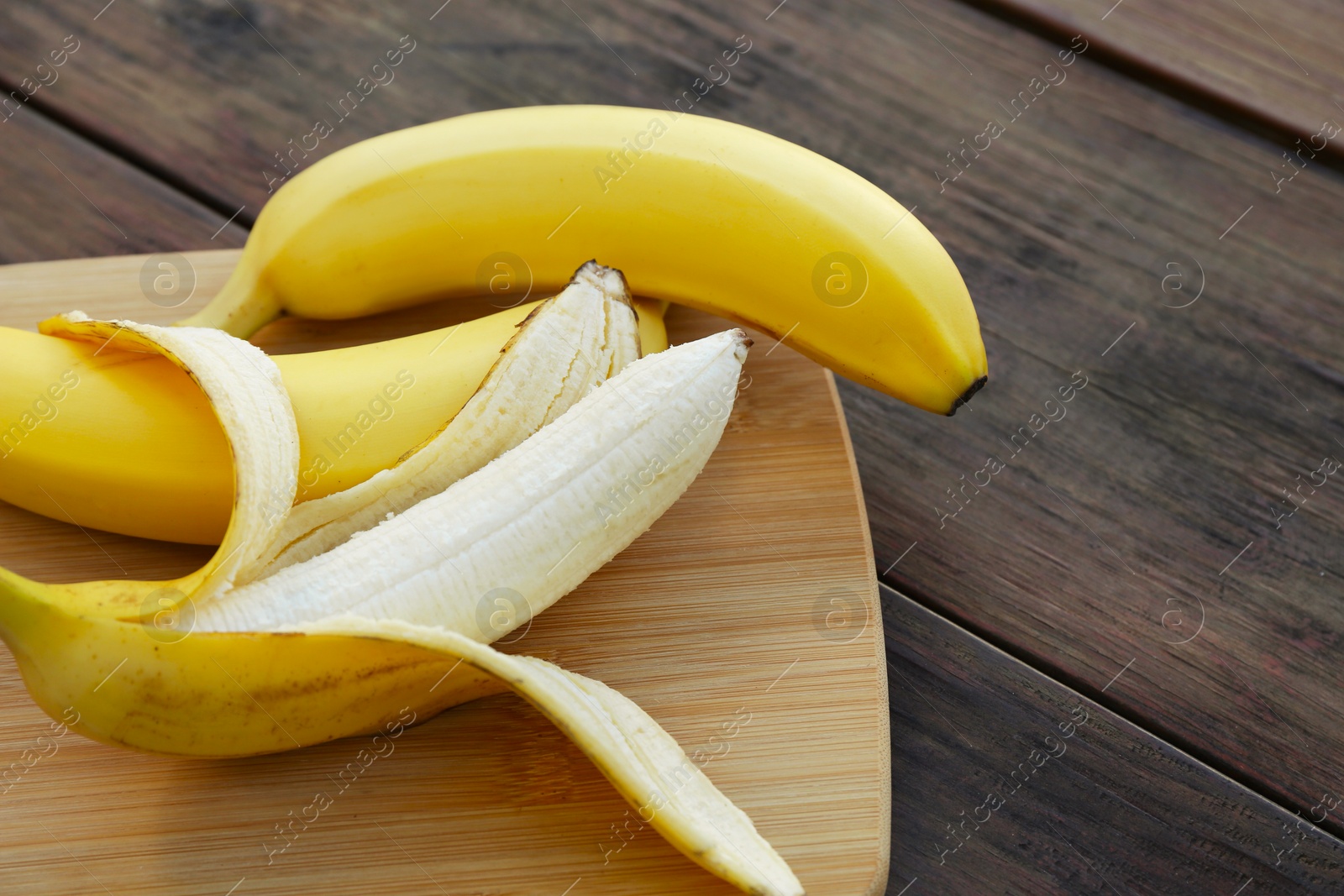 Photo of Delicious yellow bananas on wooden table, closeup