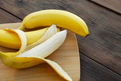 Delicious yellow bananas on wooden table, closeup