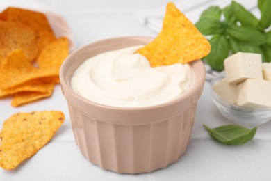 Delicious tofu sauce served with nachos chips on white table, closeup