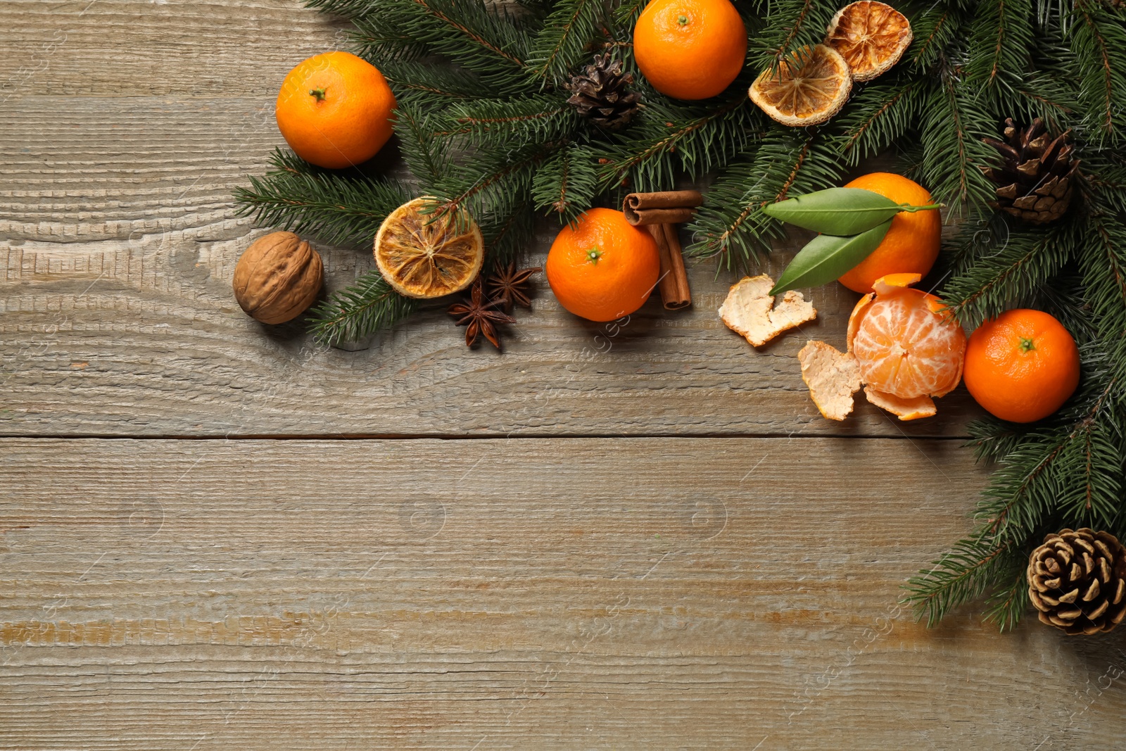 Photo of Flat lay Christmas composition with fresh tangerines and fir tree branches on wooden table, space for text