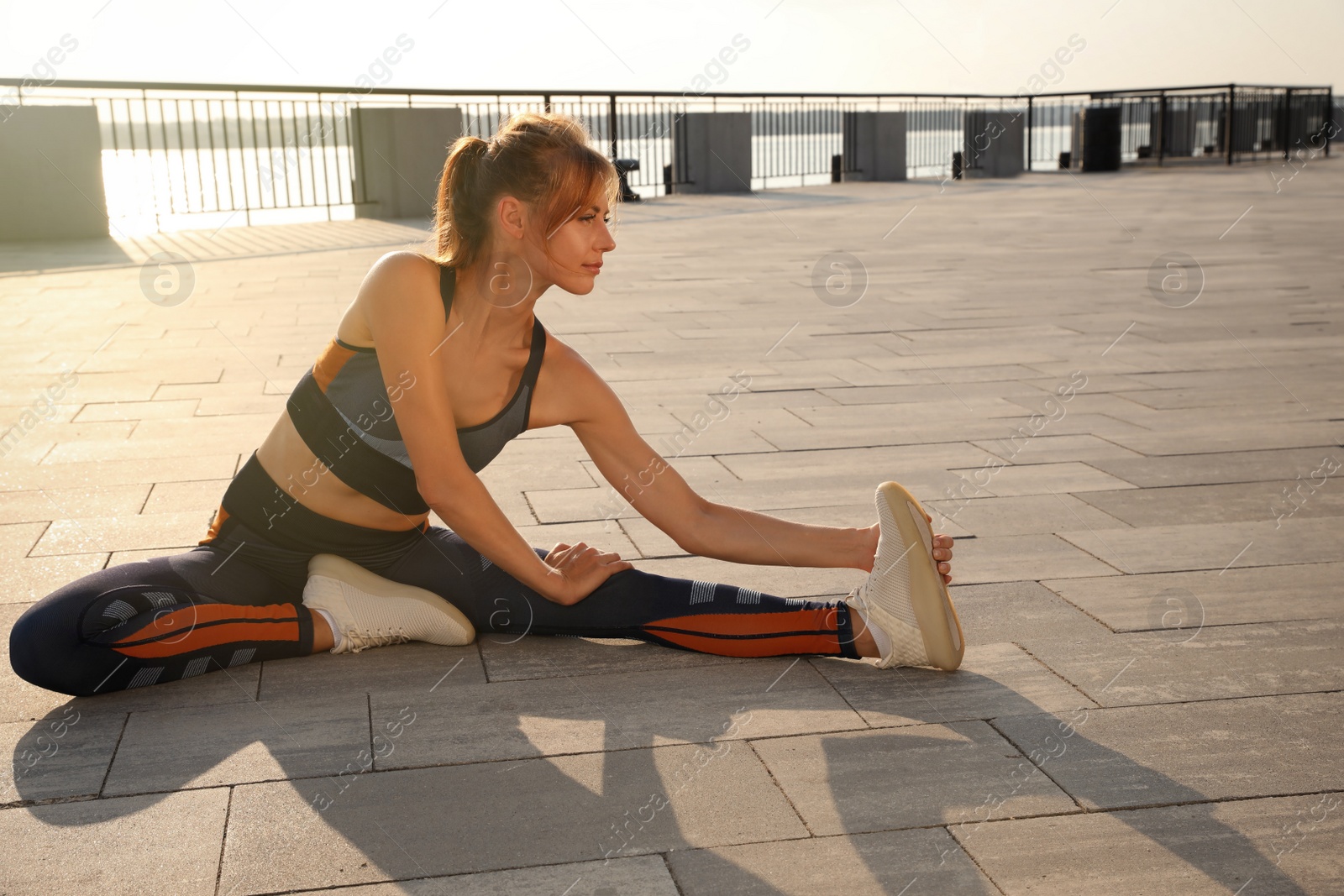 Photo of Beautiful woman in sportswear doing exercises outdoors on sunny day