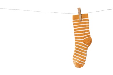 Photo of Cute child sock on laundry line against white background