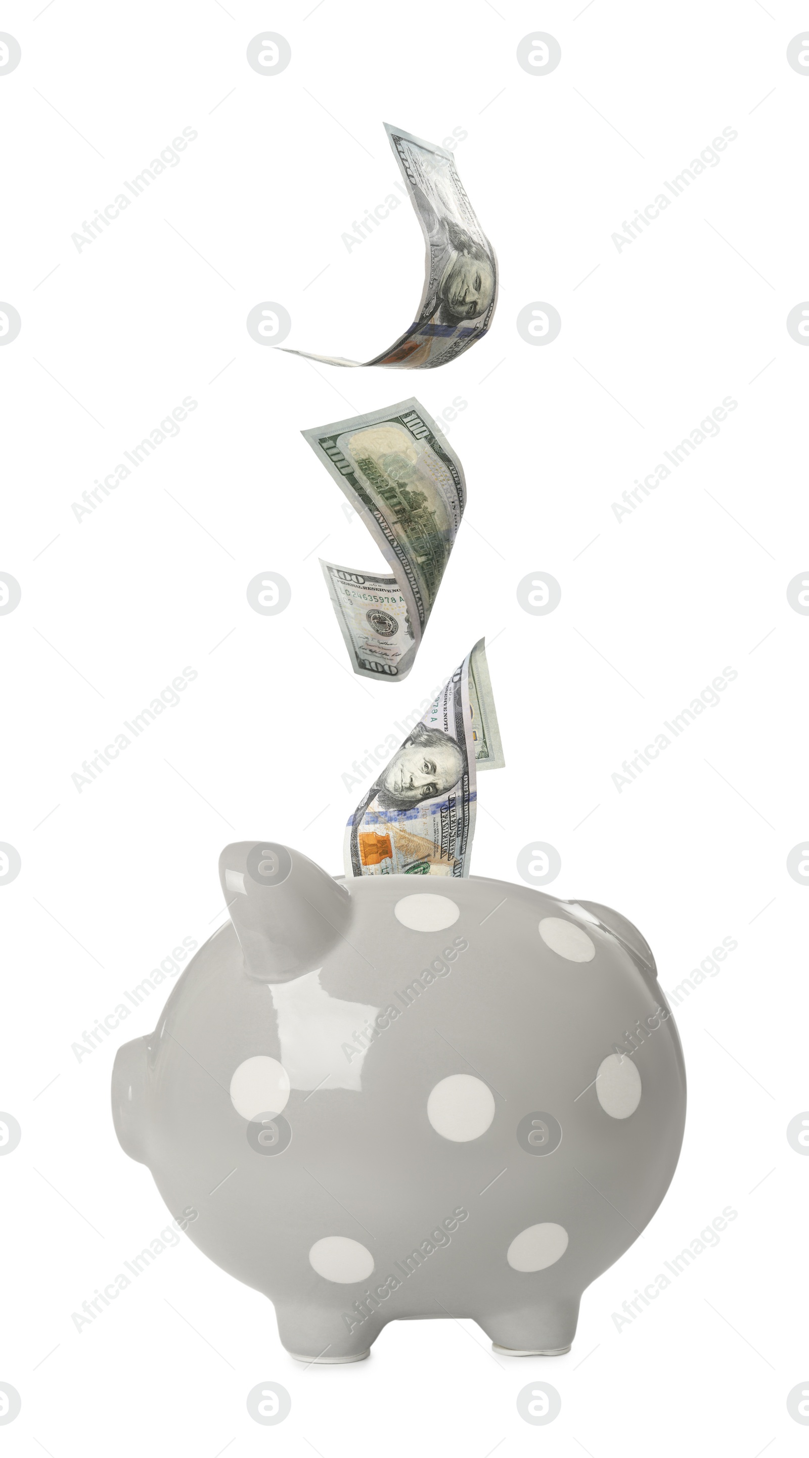 Image of Dollar banknotes falling into grey piggy bank on white background