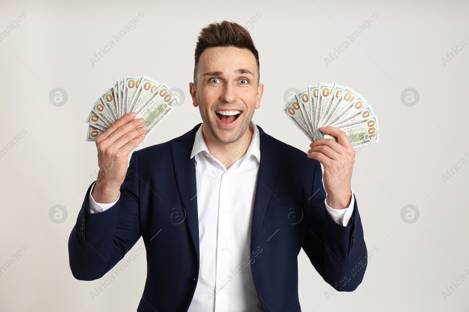 Photo of Happy man with cash money on light grey background