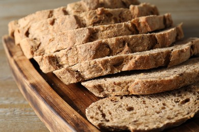 Photo of Freshly baked cut sourdough bread on wooden table, closeup