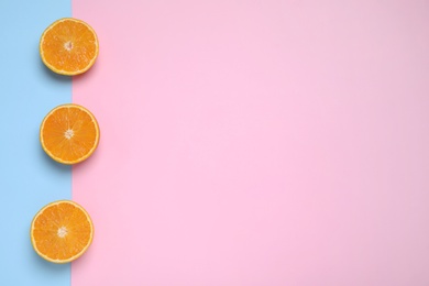 Photo of Cut oranges on color background, flat lay. Space for text