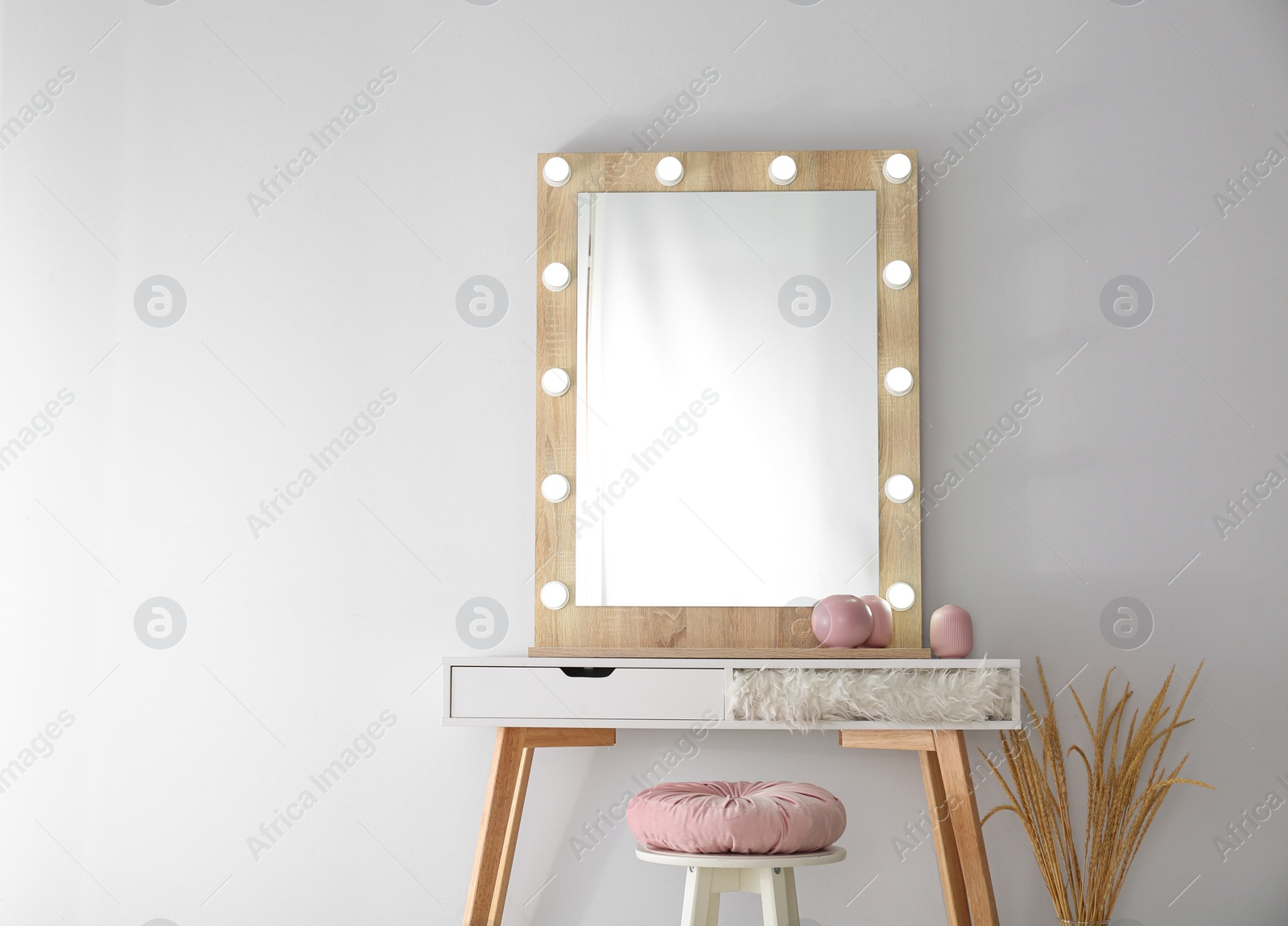 Photo of Stylish mirror with lamps near light wall in room