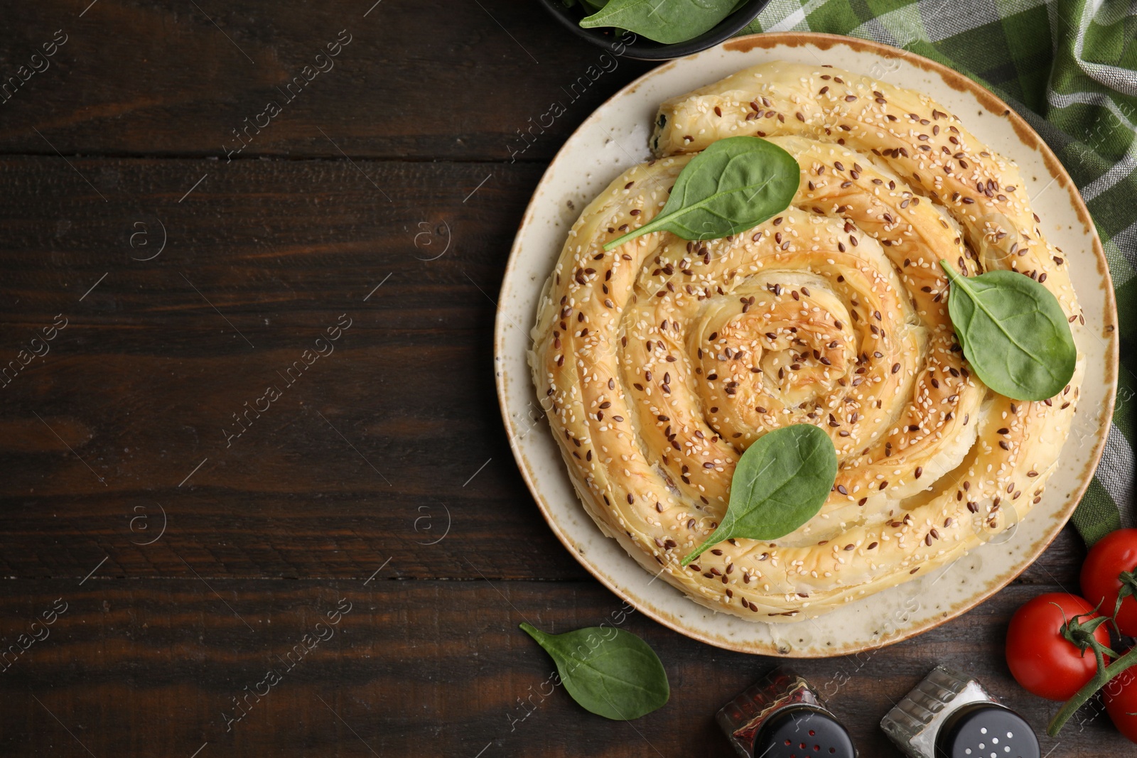 Photo of Delicious puff pastry with spinach on wooden table, flat lay. Space for text