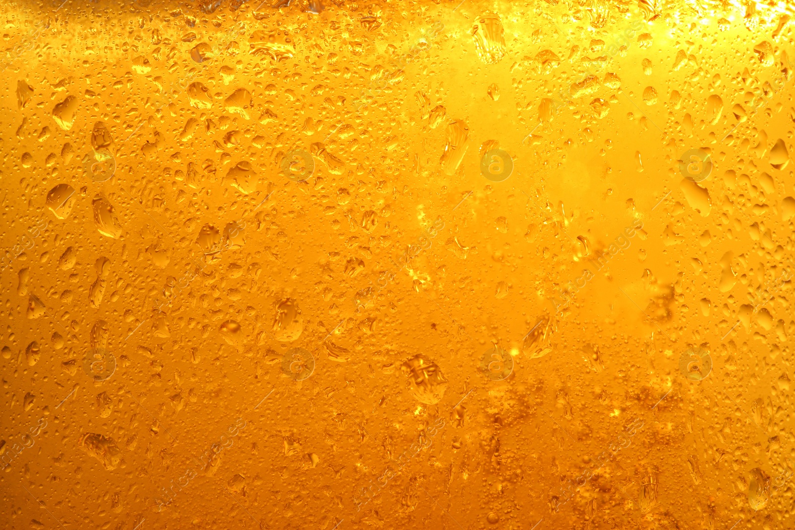 Photo of Glass of tasty cold beer with condensation drops as background, closeup