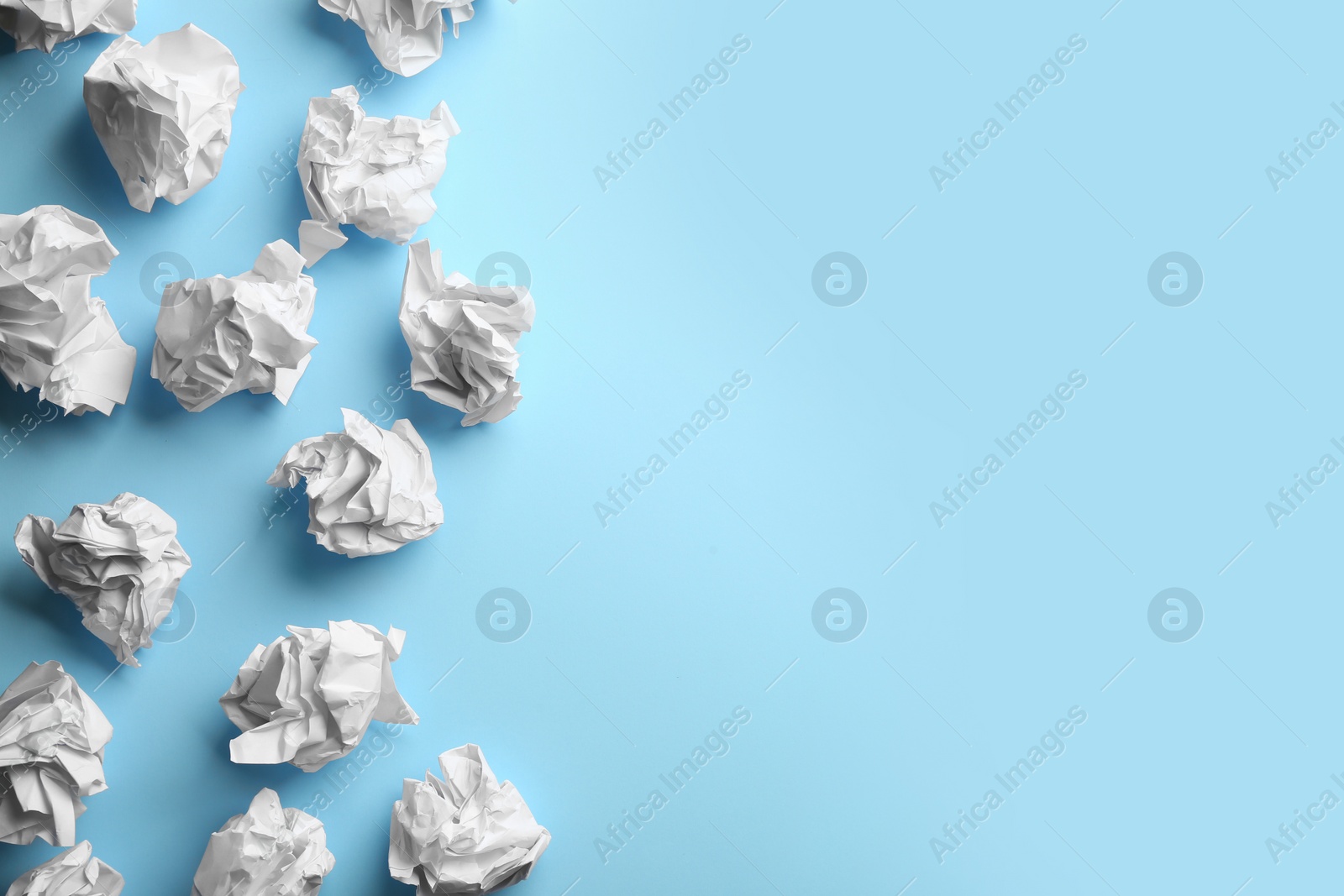 Photo of Crumpled sheets of paper on light blue background, flat lay. Space for text