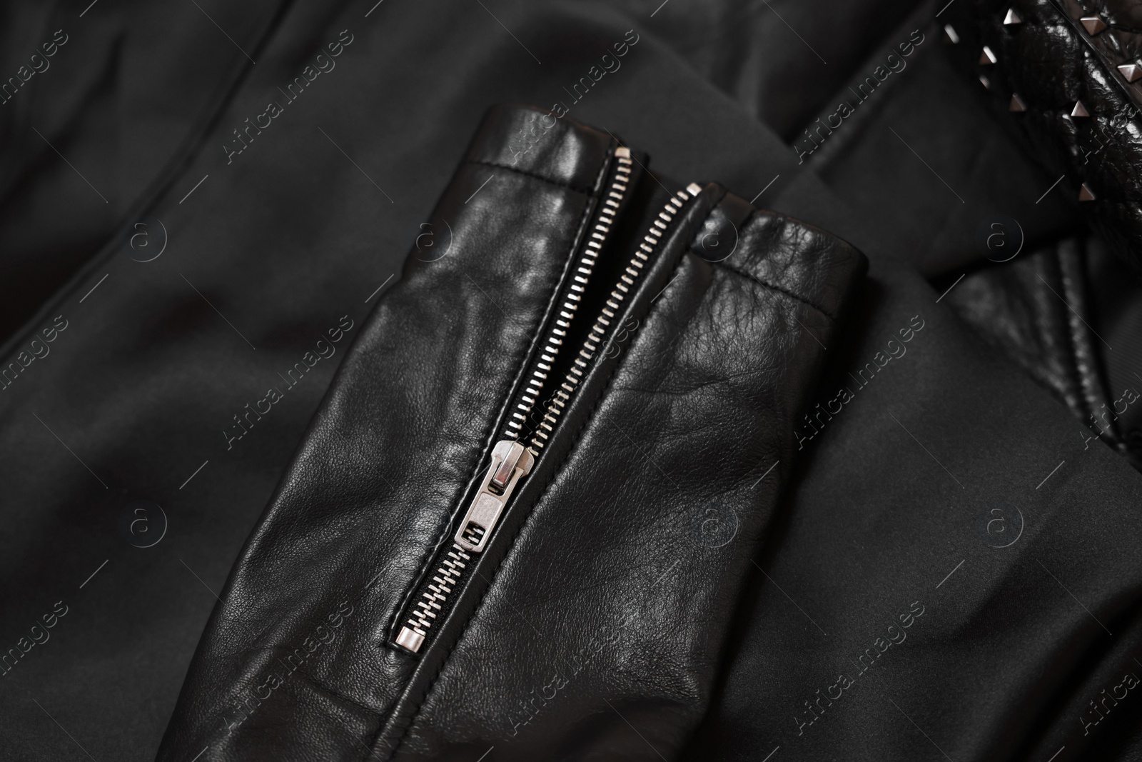 Photo of Texture of black leather jacket with zipper as background, top view