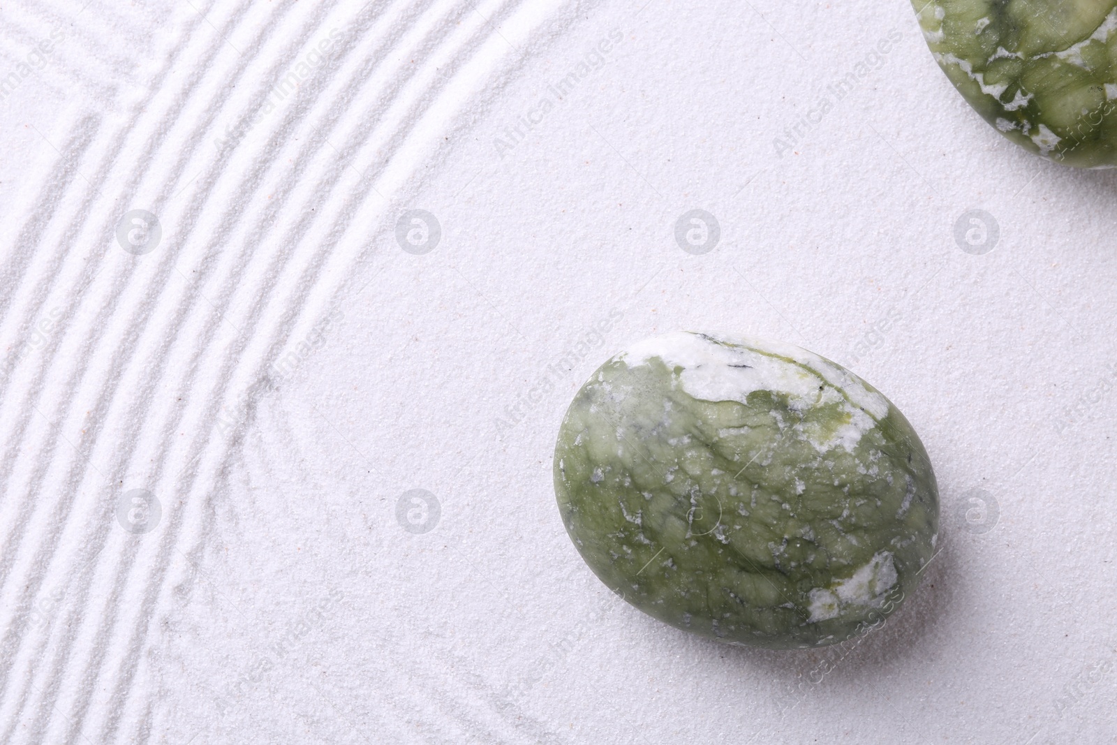 Photo of Stones on sand with pattern, flat lay. Zen concept