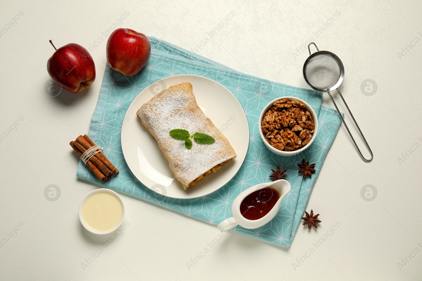 Photo of Delicious strudel with apples and ingredients on white table, flat lay