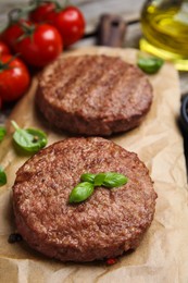 Photo of Tasty grilled hamburger patties with basil served on table, closeup