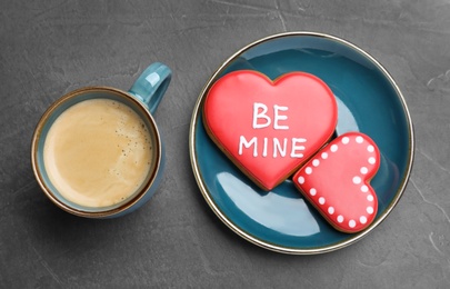 Photo of Cup of coffee and heart shaped cookies on grey table, flat lay. Valentine's day breakfast