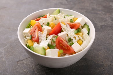 Photo of Tasty salad with Chinese cabbage, tomato, cheese, pepper and cucumber on grey table