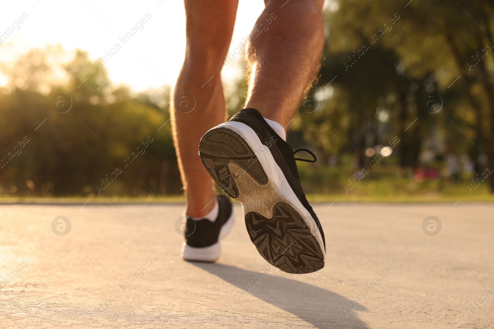 Photo of Man running outdoors on sunny day, closeup