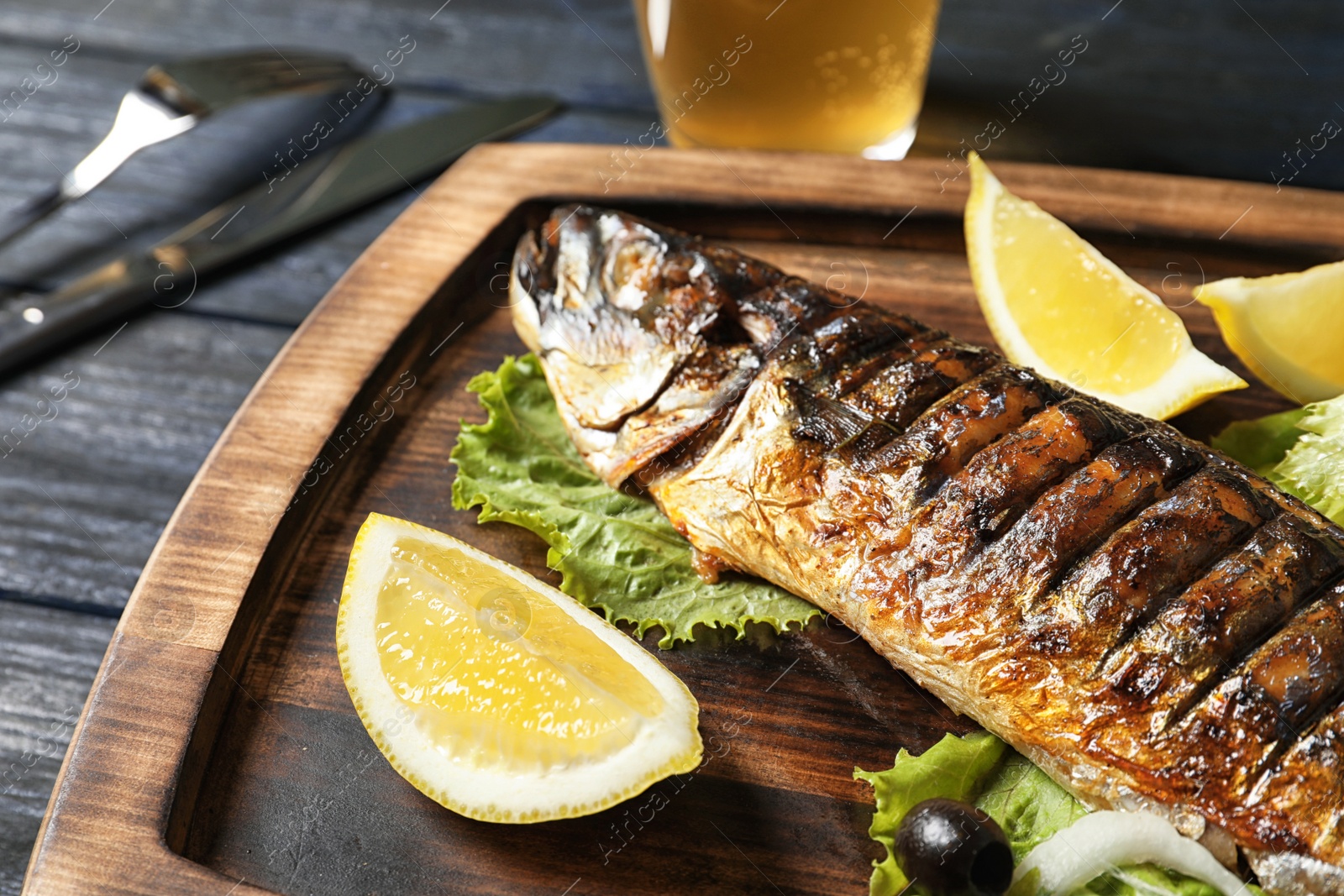 Photo of Wooden board with delicious grilled fish, closeup