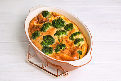 Tasty broccoli casserole in baking dish on white wooden table, top view